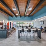 Salle de pause de bureau moderne avec éclairage naturel économe en énergie, réduisant la consommation d'énergie.