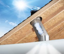 La lumière du soleil canalisée par un conduit de lumière illumine le plafond d'une pièce. Solution de lumière naturelle pour l'aménagement des combles.