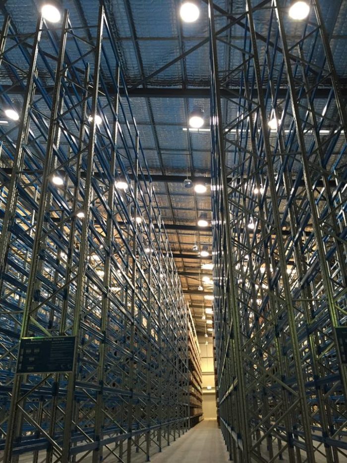 Entrepôt à hauts rayonnages avec éclairage naturel performant Solatube. Système de rayonnages de stockage performant.