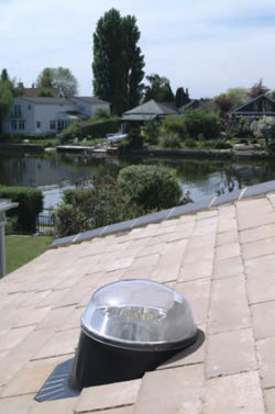 Conduit de lumière installé sur une toiture en ardoise. Solution d'éclairage naturel.