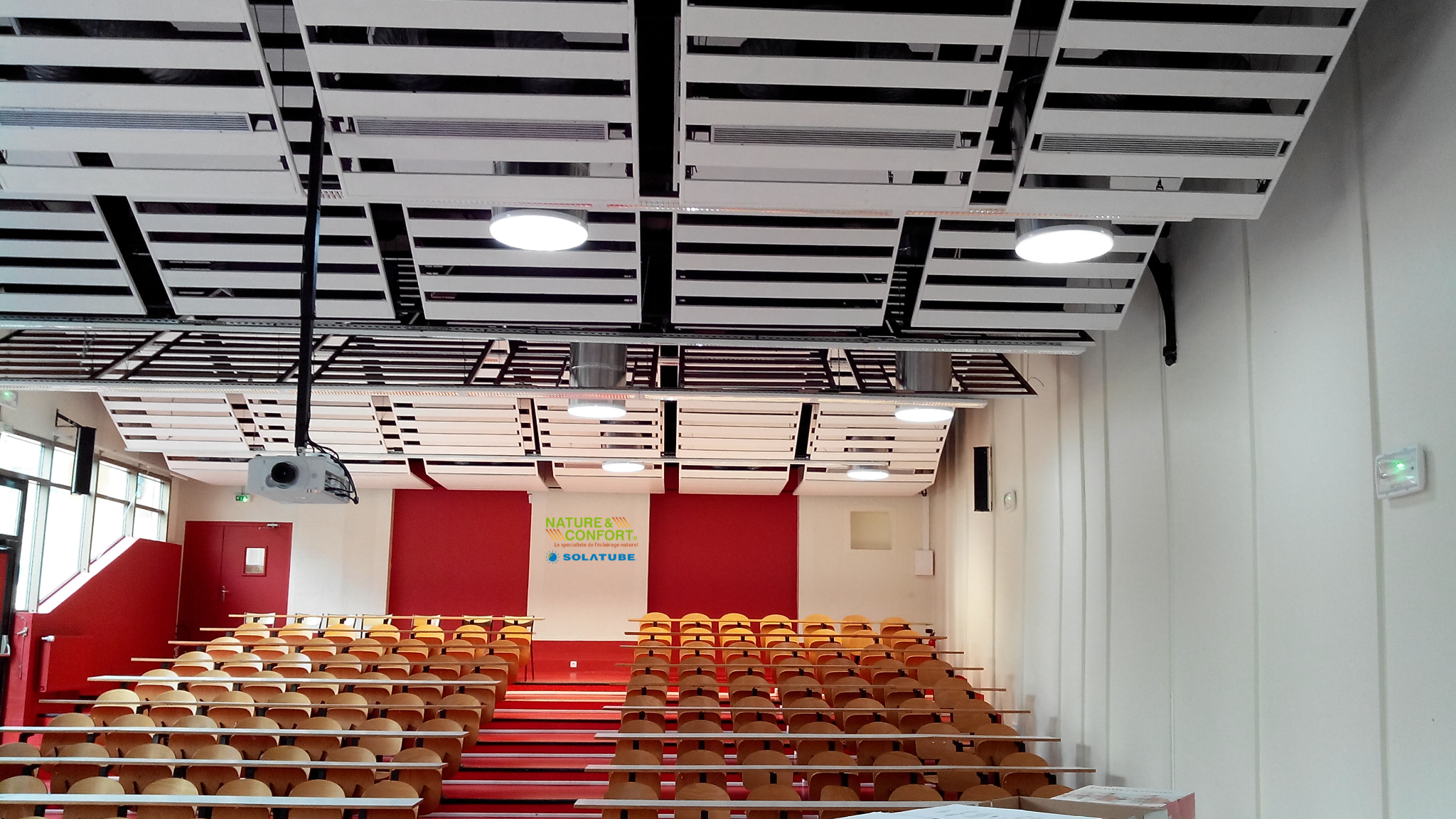 Amphithéâtre moderne avec système d’éclairage naturel optimisé. Visibles "Nature & Confort" et "Solatube".