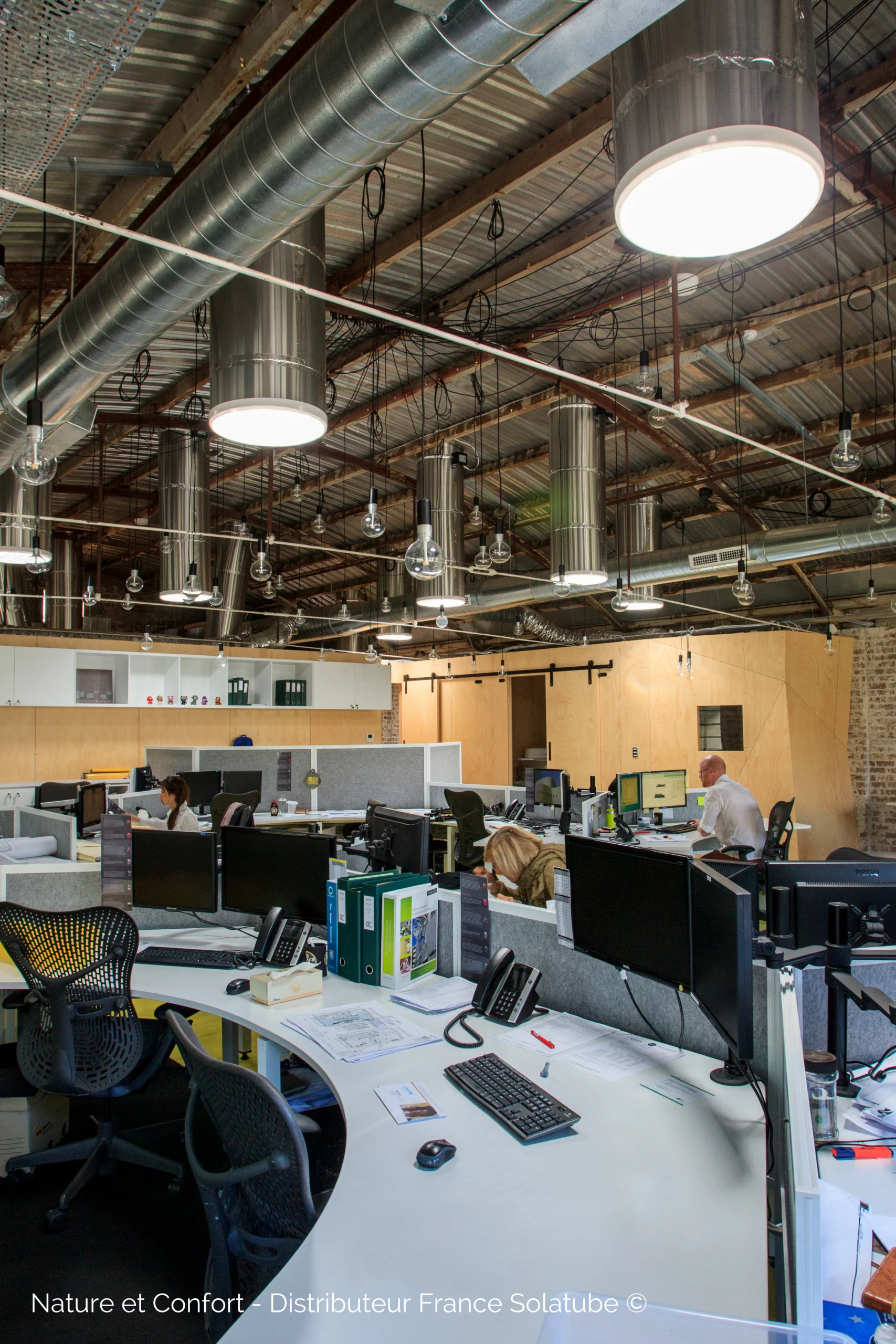 Espace de travail de bureau avec puits de lumière tubulaires apportant de la lumière naturelle