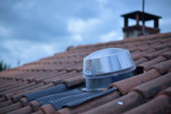 Conduit de lumière sur toiture en tuiles, élément essentiel pour l'éclairage naturel.