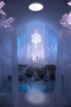 Chambre d'hôtel de glace avec une grande sculpture de flocon de neige et des conduits de lumière