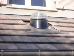 Conduit de lumière sur un toit de tuiles grises